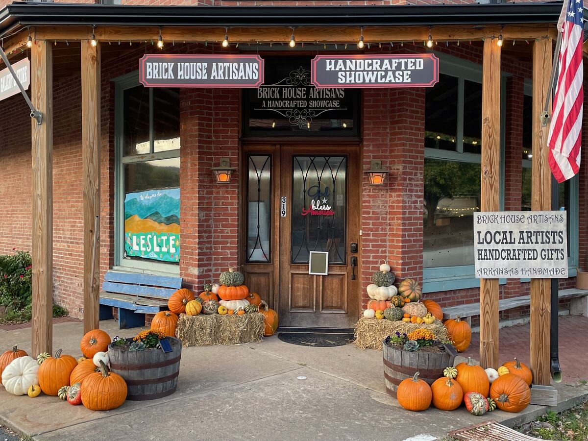 Pumpkins clustered on steps beneath an autumn wreath