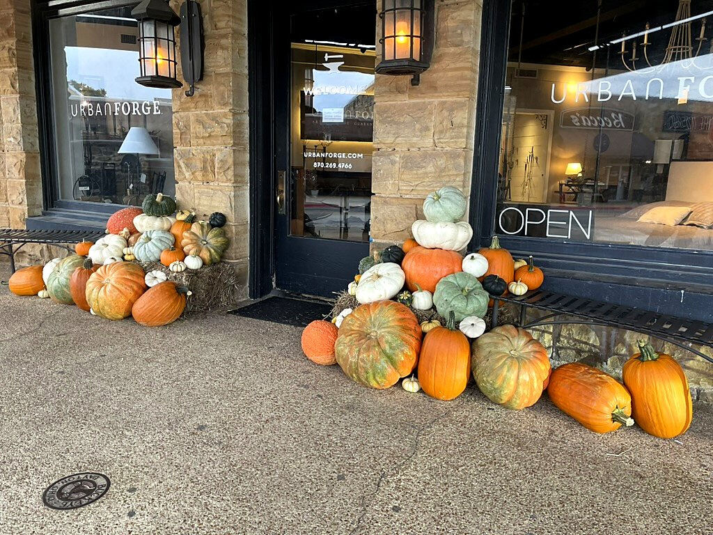 Heirloom pumpkins banked on both sides of a stone storefront's door
